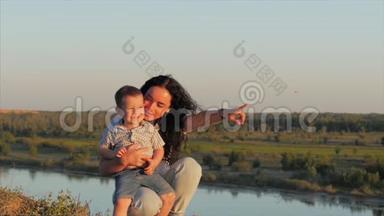 母亲拥抱儿子的肖像。 家人拥抱在夕阳的天空背景上。 库存录像。